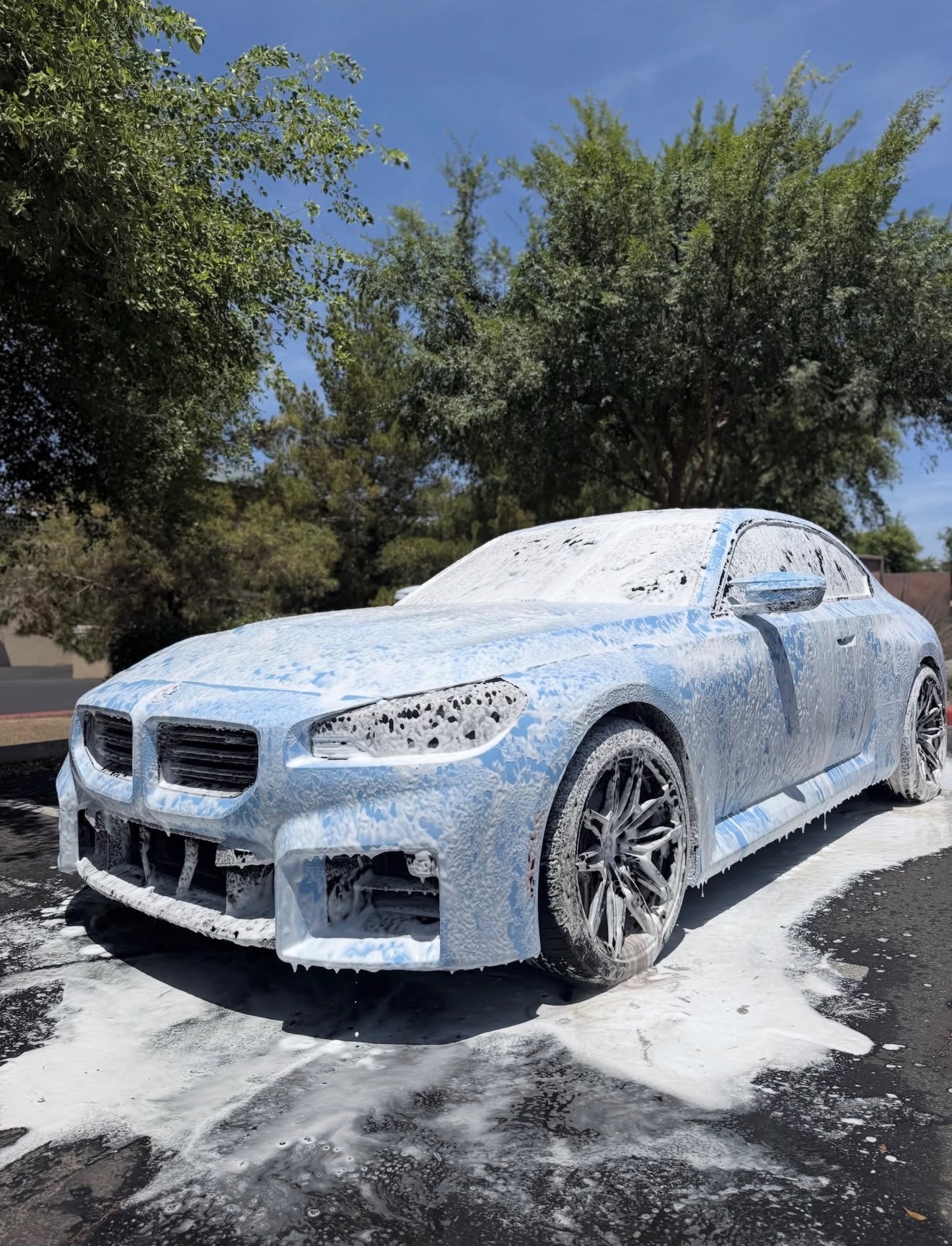 BMW M2 covered in snow foam during an exterior detail